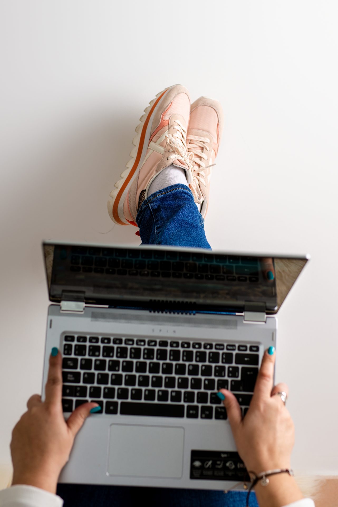 imagen de pies con un ordenador sobre ellos en fondo blanco