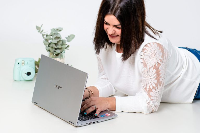 Chica haciendo consultoria de marketing digital tumbada en el suelo con ordenador portátil